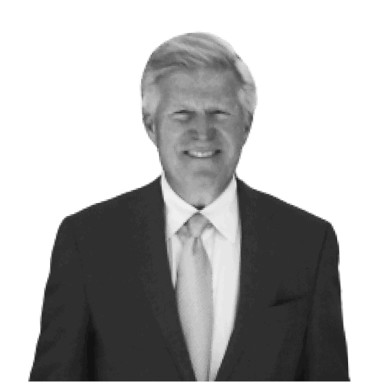 A white man with white hair is smiling and wearing a suit and tie.