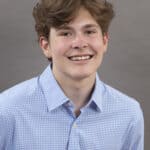 Headshot of Ian Trabuco, man smiling with blue dress shirt on